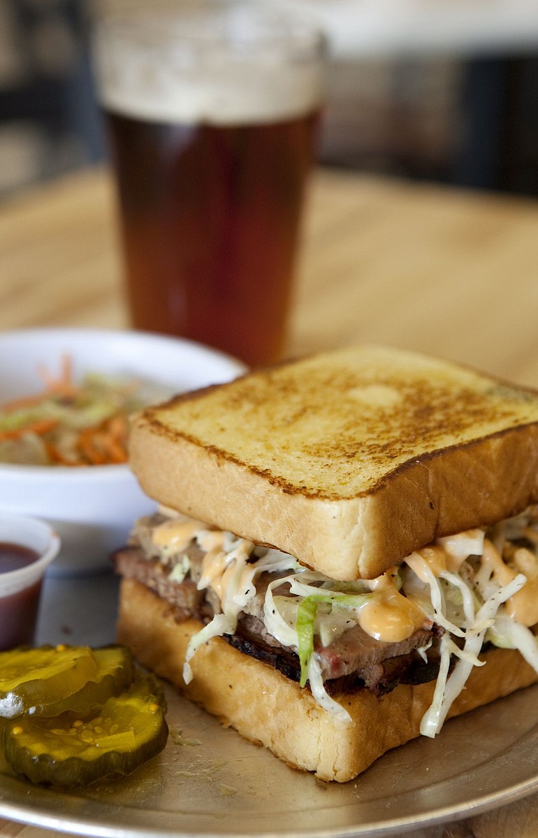 An Okie Reuben with a side of Spicy Slaw is served with an Amber Ale at Jazzy John's BBQ.