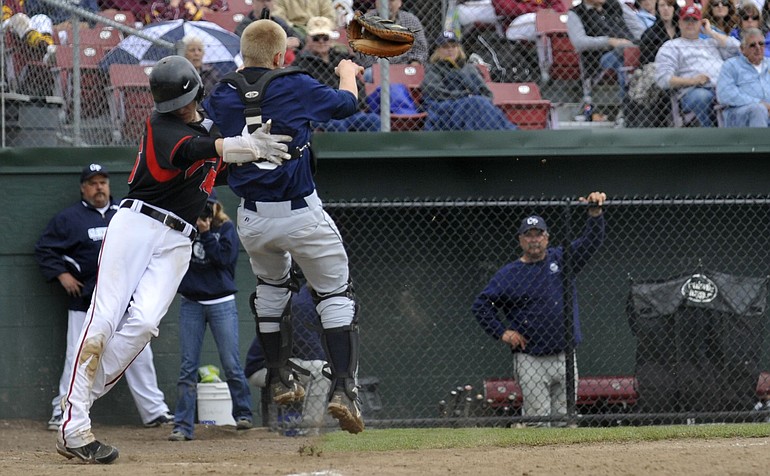Camas' Maxx Gillhamer, left, collides with Glacier Peak catcher Kevin Campbell during the first regional game Saturday in Centralia.