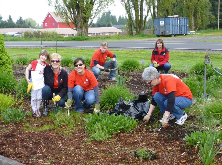 Employees from Keller Williams Realty spruce up the landscape at Rocksolid Teen Center in Battle Ground on RED Day.