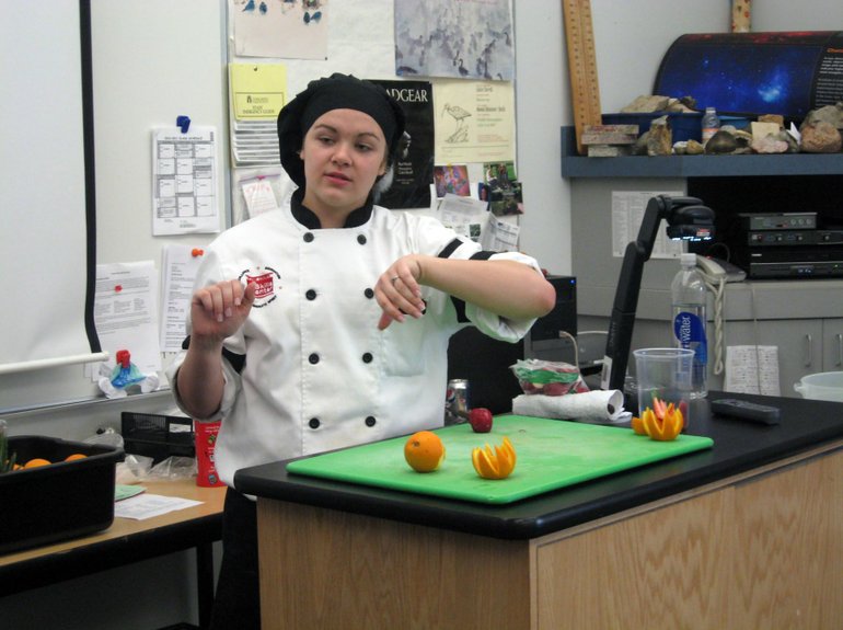Image: Jamie Miller, a Skills Center restaurant management student, gives Cascade Middle School students a demonstration.