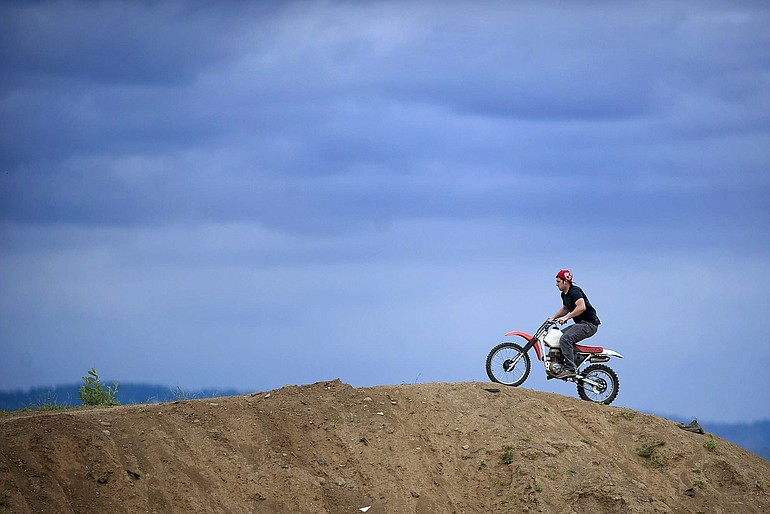 Mike Mercer, 26, of east Vancouver rides a motorcycle Wednesday on top of a dirt mound on a lot owned by Sifton Orchards LLC and adjacent to a lot where Walmart has delayed construction of a store in east Vancouver.