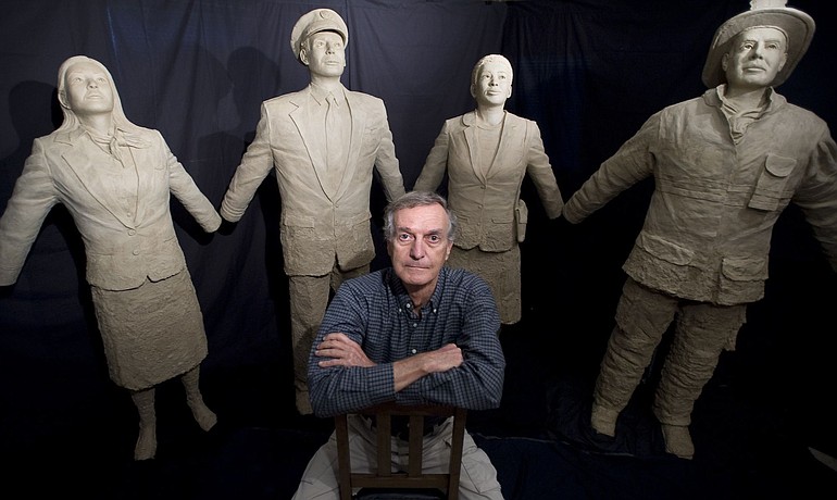 Battle Ground artist Jim Demetro poses in front of four separate statues that commemorate 9/11.