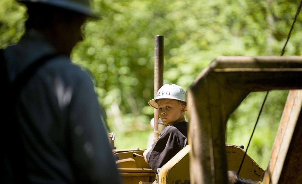 Carson DeRoo, 11, from Yacolt, drags logs through the forest with a Catapillar at the Pomeroy Living History Farm's steam logging show Saturday.