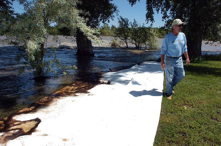 Jim Swanson is seen in his yard east of Laurel, Mont., where absorbent sheets were laid down to soak up oil from a ruptured ExxonMobil pipeline beneath the Yellowstone River Saturday.