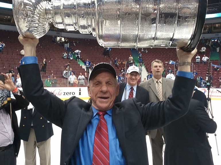 Vancouver's Tom McVie raises Lord Stanley's Cup.