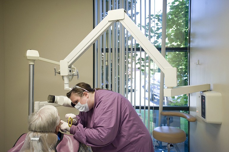 Dental assistant Traci Cotton X-rays a patient's mouth at New Day Community Dental Clinic in Vancouver last week.