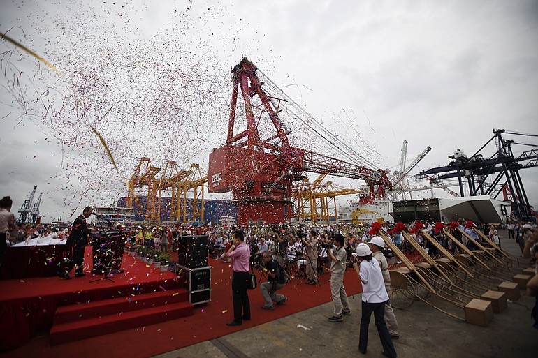 Confetti fills the air as fireworks are launched during the completion ceremony for work on the San Francisco-Oakland Bay Bridge at Shanghai Zhenhua Heavy Industries Co..