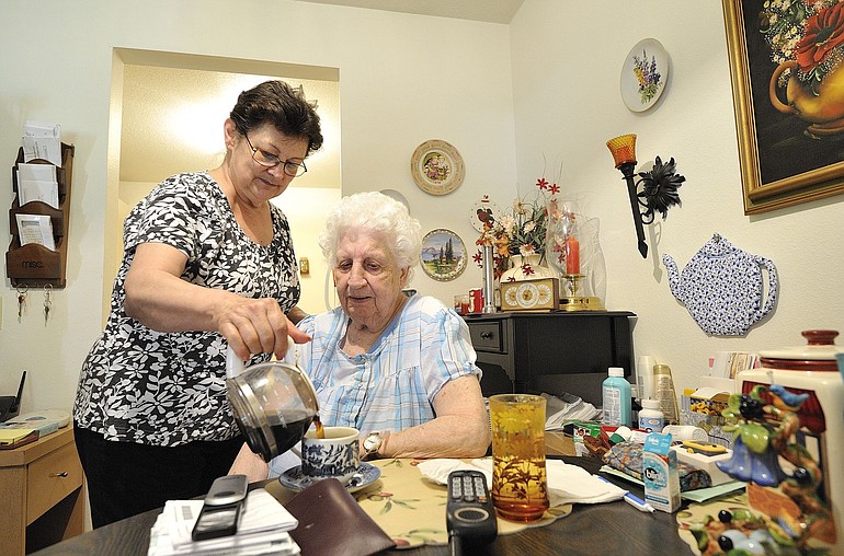 Caretaker Jean Bray, 66, left, pours a cup of coffee for her client, Jean Prew, 90, last week at Prew's home in Vancouver.