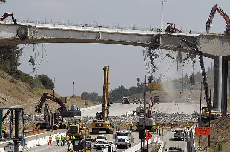 Construction workers take down the Mulholland Drive bridge over Interstate 405 in Los Angeles on Saturday. Traffic in the Los Angeles area is so far moving smoothly, several hours after authorities shut down a 10-mile stretch of one of the busiest U.S.