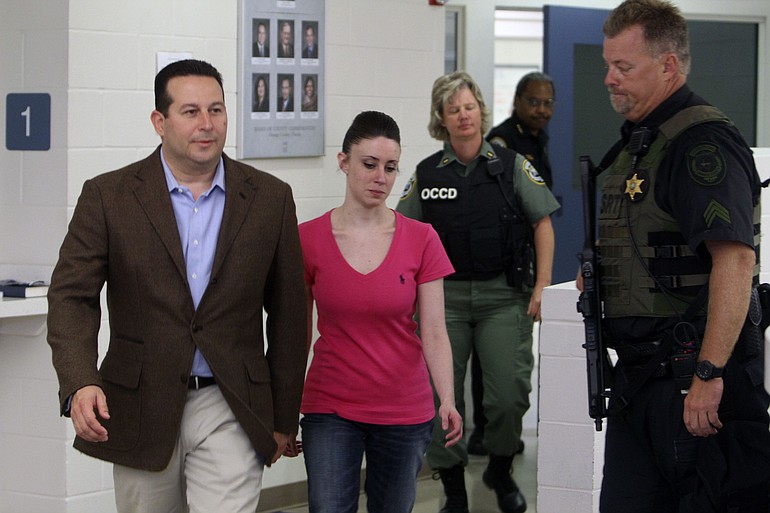 Casey Anthony, center, walks out of the Orange County Jail early today in Orlando, Fla., with her attorney Jose Baez, left.