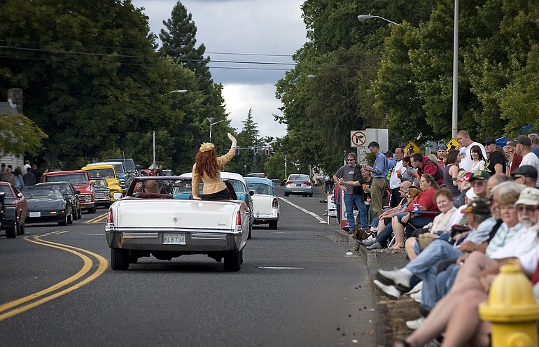 A passenger waves from the back seat of a convertible near the Main Street DQ during the third annual &quot;Cruisin' the Gut.&quot; Cars and crowds packed the Vancouver arterial, from early Saturday afternoon until well into evening.