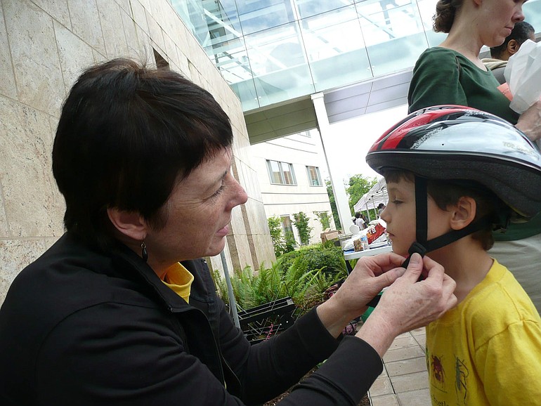 Debbie Mansell, a Legacy Salmon Creek Medical Center employee, fits a bicycle helmet during the annual Healthy Kids Fair in June.