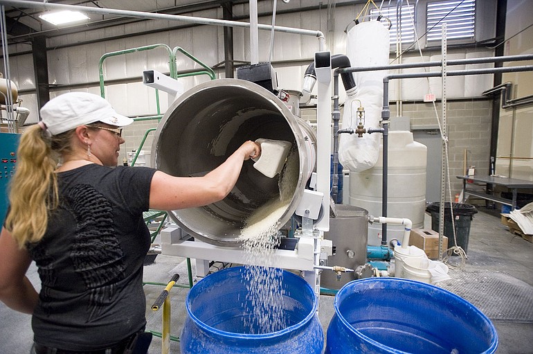 Production manager Melissa Asbury adds powder to hot-melt adhesive pellets to keep them from sticking together.