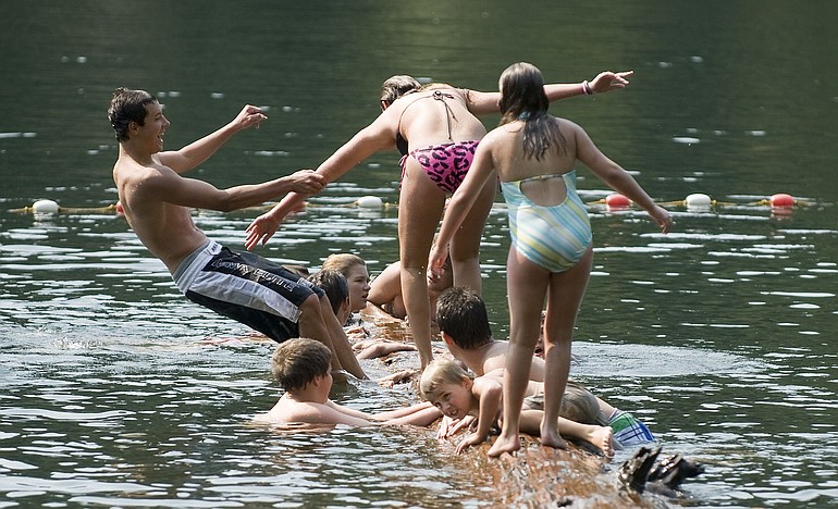 Swimmers enjoy a floating log in the roped-off section of Battle Ground Lake -- generally a good place to play, but with no lifeguard -- in August 2010.