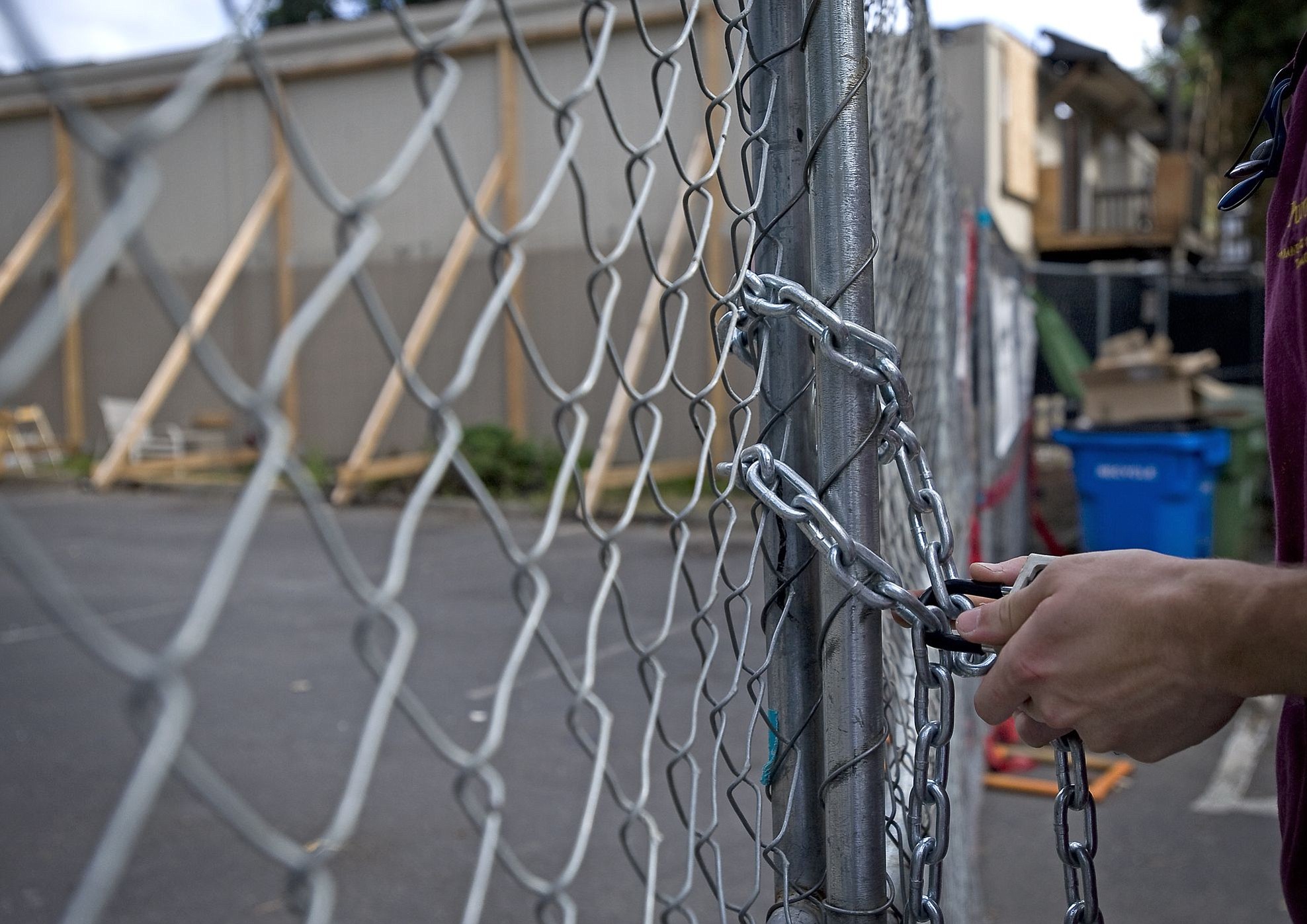 Jacob Dye, a technician assistant with PuroClean Portland, locks up a gate for the day at Rolling Creek Apartments.