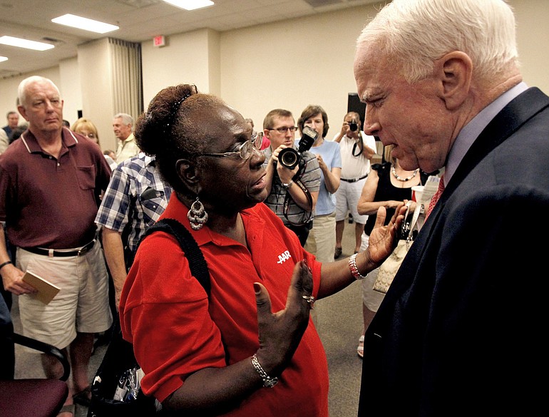 Sen. John McCain, R-Ariz., right, talks with an attendee during a town hall meeting in Aug. 23 in Goodyear, Ariz.