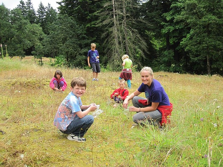 Camas: Summer camp students save flower seeds in the Camas lily fields.