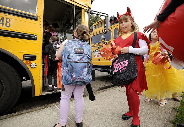 Cameryn Ramseyer, 6, a first-grade student, proves that even a devil has to wait to board the school bus on Halloween Monday afternoon at Hathaway Elementary School in Washougal.
