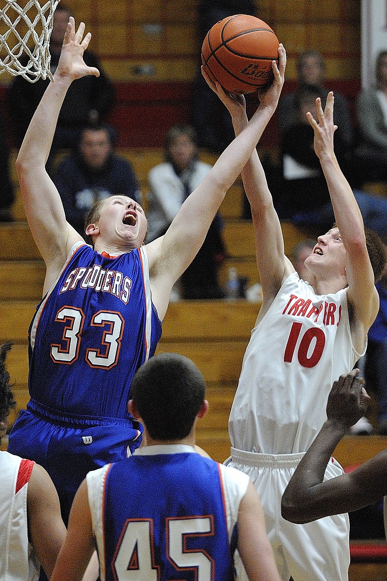 Ridgefield's Michael Potter (33) battles Fort Vancouver's Matthew Delisle (10) for a rebound during the Spudders' 63-60 overtime victory over the Trappers in the season opener for both teams.