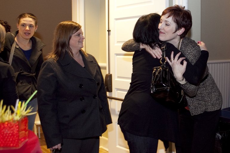 Renee Newman, right, director of retail banking, hugs a fellow co-worker from First Independent Bank at the employee goodbye party Wednesday evening at the Fort Vancouver Artillery Barracks.