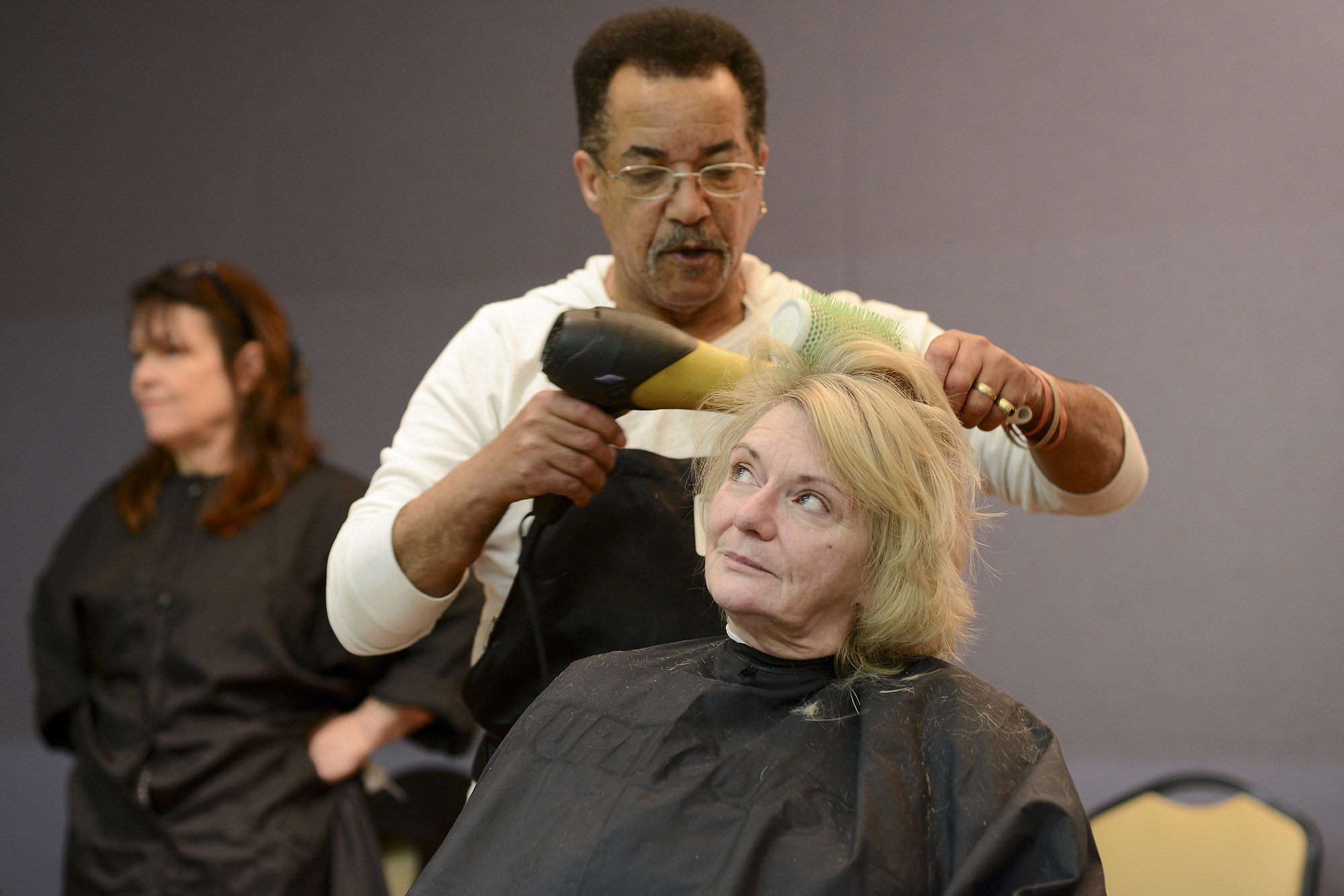 Photos by Ariane Kunze/The Columbian
Carmen Dean gets her hair cut and styled by Derek Thompson on Thursday at Project Homeless Connect at St. Joseph Catholic Church in Vancouver. Dean attended the annual event to receive mental health services, a flu shot and some new clothes, she said.