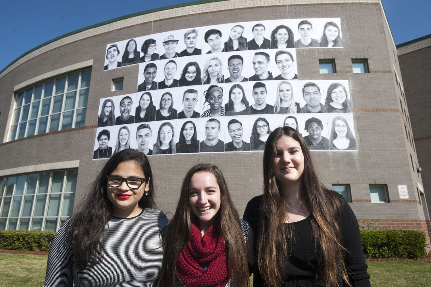 At Skyview High School, behind student photographers Rubyna Ali, from left, Shelby Sherman and Marta Alcazar, are the 40 portraits they selected to represent the school's diversity.