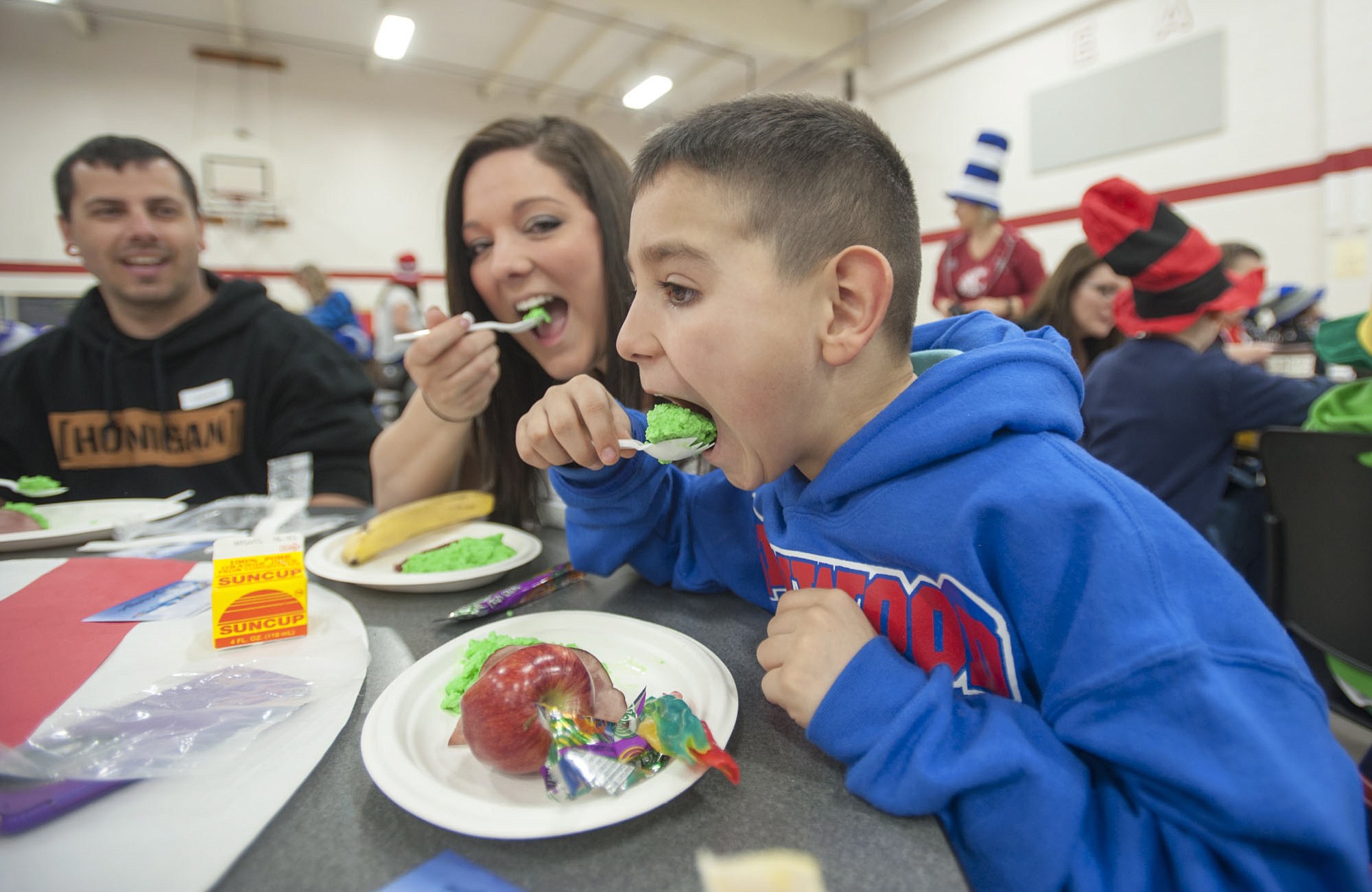 First-grader Skyler Dassinger takes a giant bite of green scrambled eggs with his mom, Cassandra Gonzalez, on Wednesday at the annual Green Eggs and Ham breakfast at Walnut Grove Elementary School in Vancouver.