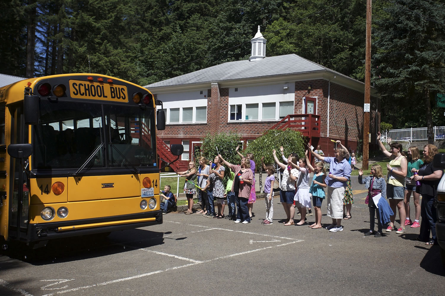 On the last day of the school year at Green Mountain School, staff members blow bubbles and wave goodbye to students on departing buses.