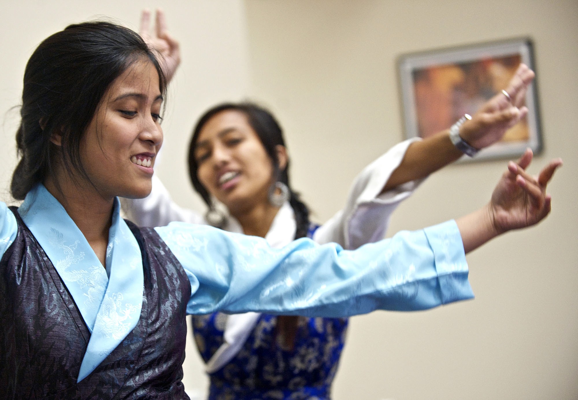 Nepalese visitors Manisha Sunuwar, 20, left, and Pooja Ghimire, 21, perform a traditional Nepalese dance at Shared Hope International on Friday.