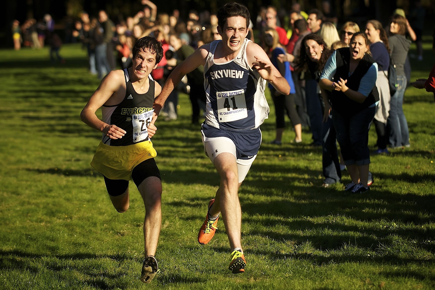 Dan Poyfair, right, of Skyview High School holds off Taryn Sciortino, left, of Evergreen High School at the finish line in the boys 4A district cross country meet Wednesday October 23, 2013 at Lewisville Park in Battle Ground, Washington. The Skyview boys cross country team won the district meet.