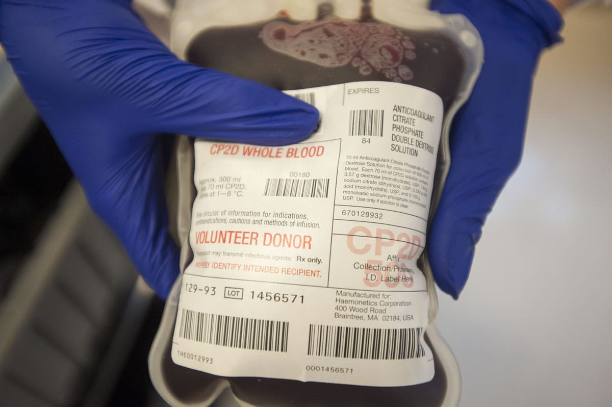 A technician holds a bag of fresh blood during Bloodworks Northwest’s community picnic and blood drive at the group’s Vancouver donation center in August 2015.