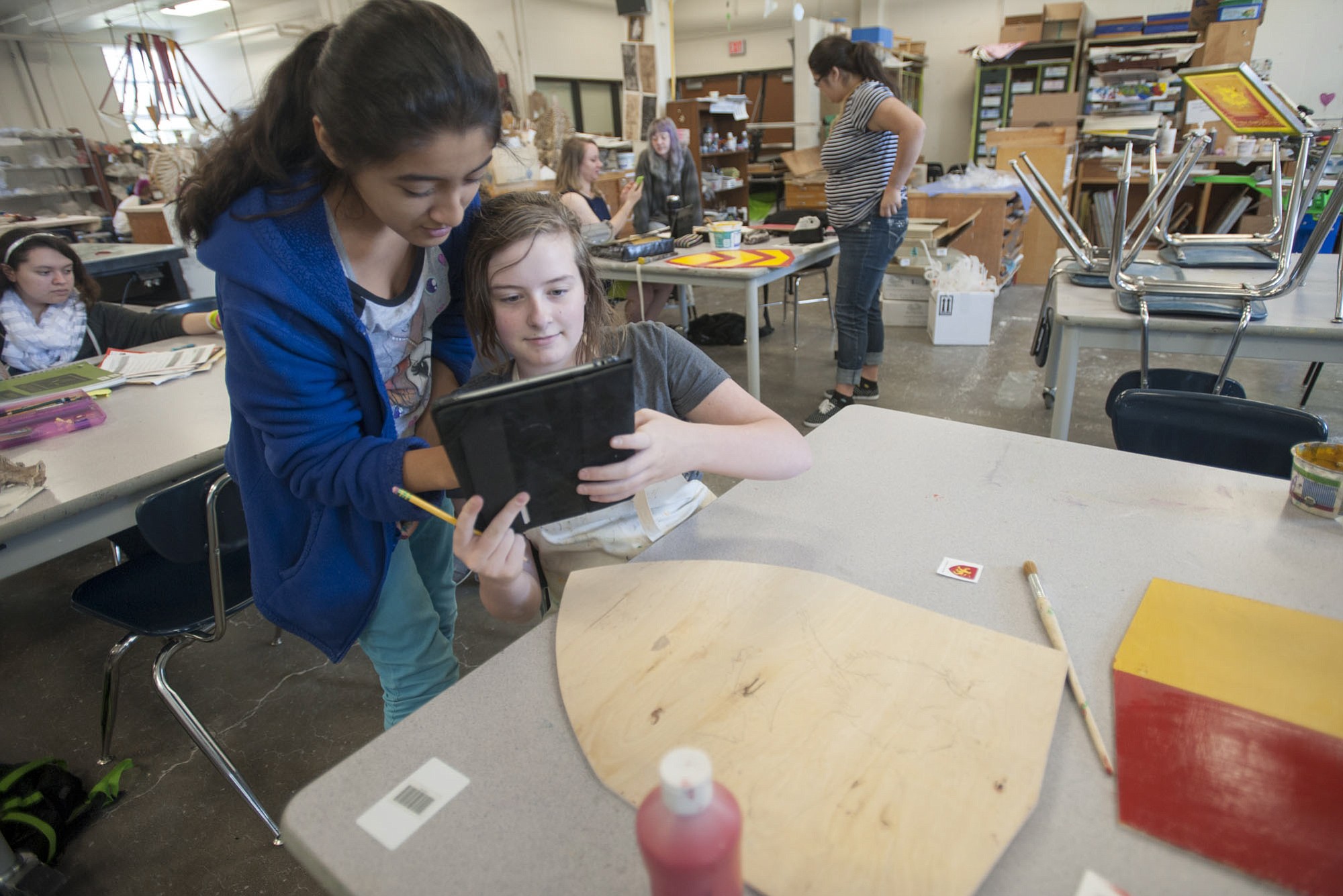 Savanna Falkner, a student at Vancouver School of Arts and Academics, uses an iPad earlier this month to show a classmate how she will paint a shield representing William de Lanvallei, an English baron during the 13th century.