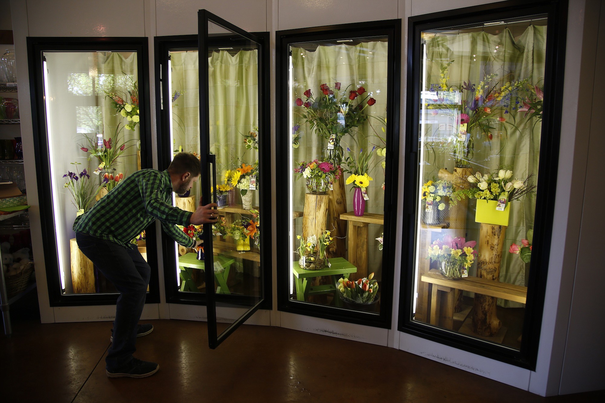 Erik Witcraft, general manager and lead designer at Flowers Washougal, works on a display at the store.