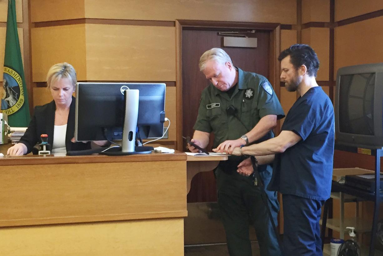 Clean energy entrepreneur John Garrett Smith is fingerprinted in Clark County Superior Court after being sentenced to 12 years in prison for the attempted murder of his wife.