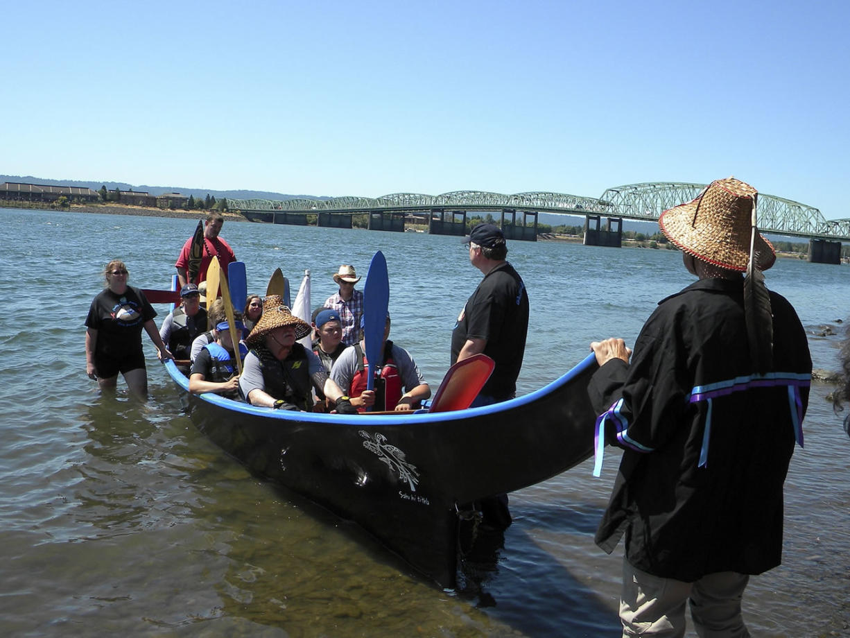 Tom Vogt/The Columbian
The Cowlitz Canoe Family includes paddlers of a range of ages, with the purpose of passing on Cowlitz heritage.
Skipper Jeramiah Wallace, at the stern, announces the arrival of the Cowlitz Canoe Family early Tuesday afternoon on the north shore of the Columbia River.