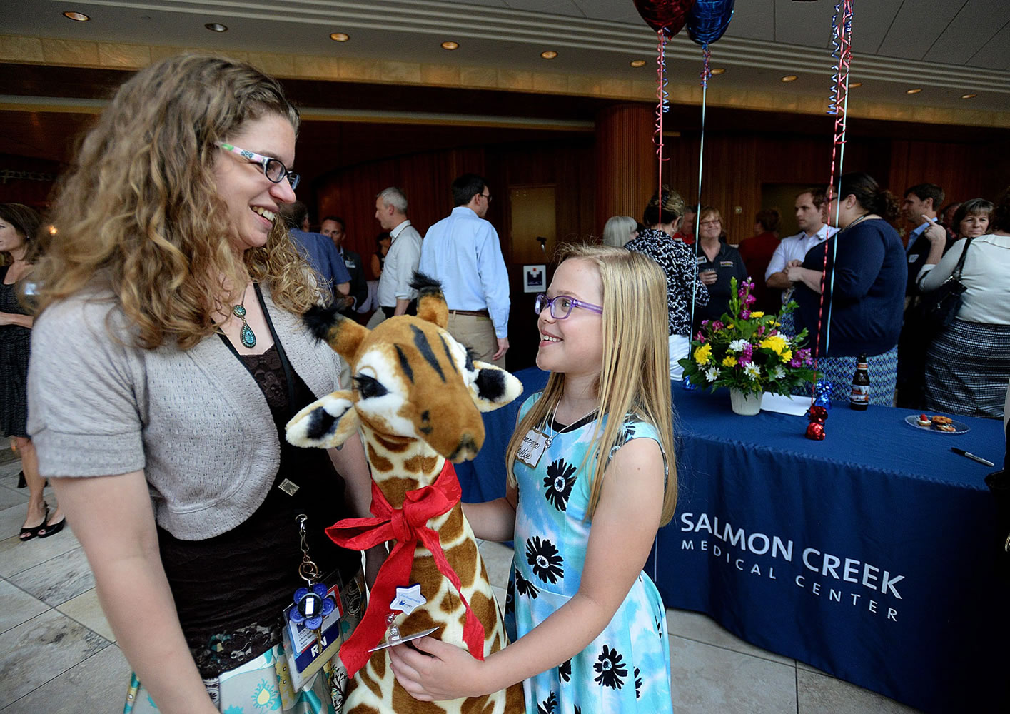 Kacia Gauthier, neonatal intensive care unit manager at Legacy Salmon Creek Medical Center, left, wishes Breanna Bullion of La Center a happy 10th birthday after presenting the girl with a stuffed giraffe from the hospital staff. Breanna was the first patient at the Salmon Creek hospital when it opened 10 years ago.