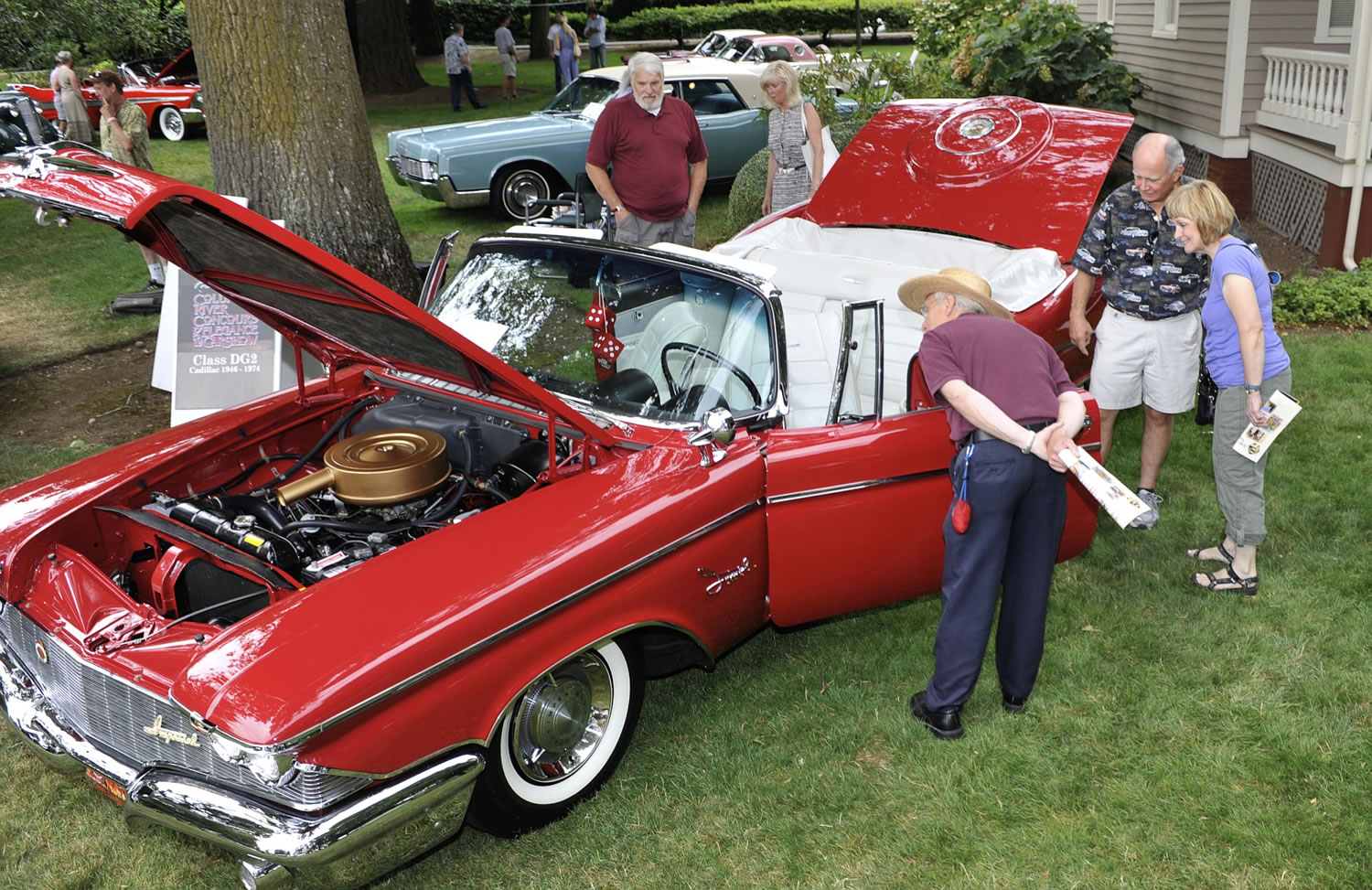 Visitors admire a 'Regal Red' 1960 Chrysler Crown Imperial owned by Joel Holland of Sumner, Wa, at the 2015 Concourse d'Elegance at Officers Row in the Fort Vancouver historic site in Vancouver  Wa., Sunday August 2, 2015.