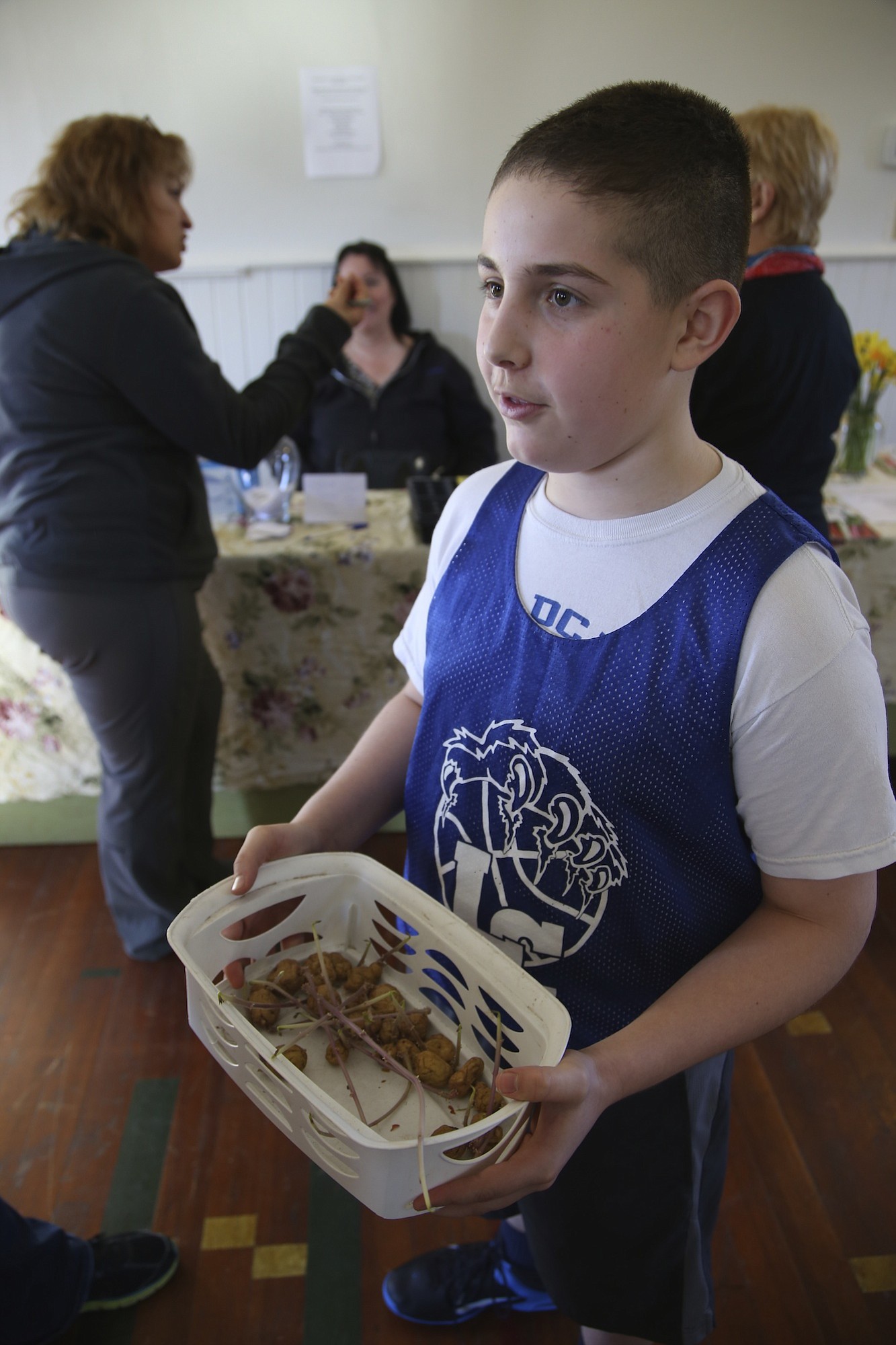 Jacob Luiz, 12, brings a basket of Yukon Gold seed potatoes to the Great Clark County Seed Swap at the La Center Grange.