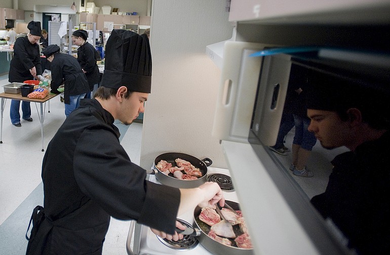 Camas High student Chris Ontkean, 18, browns chicken legs and thighs while preparing Coq Au Vin, or chicken with wine, a traditional French dish, Saturday during the 3rd Annual Clark County High School Culinary Competition at Battle Ground High School.