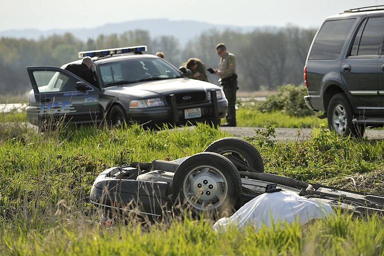 Investigators from the Clark County Sheriff's Office and Ridgefield Police Department examine the scene of an car accident on Sunday at the Ridgefield Wildlife Refuge.