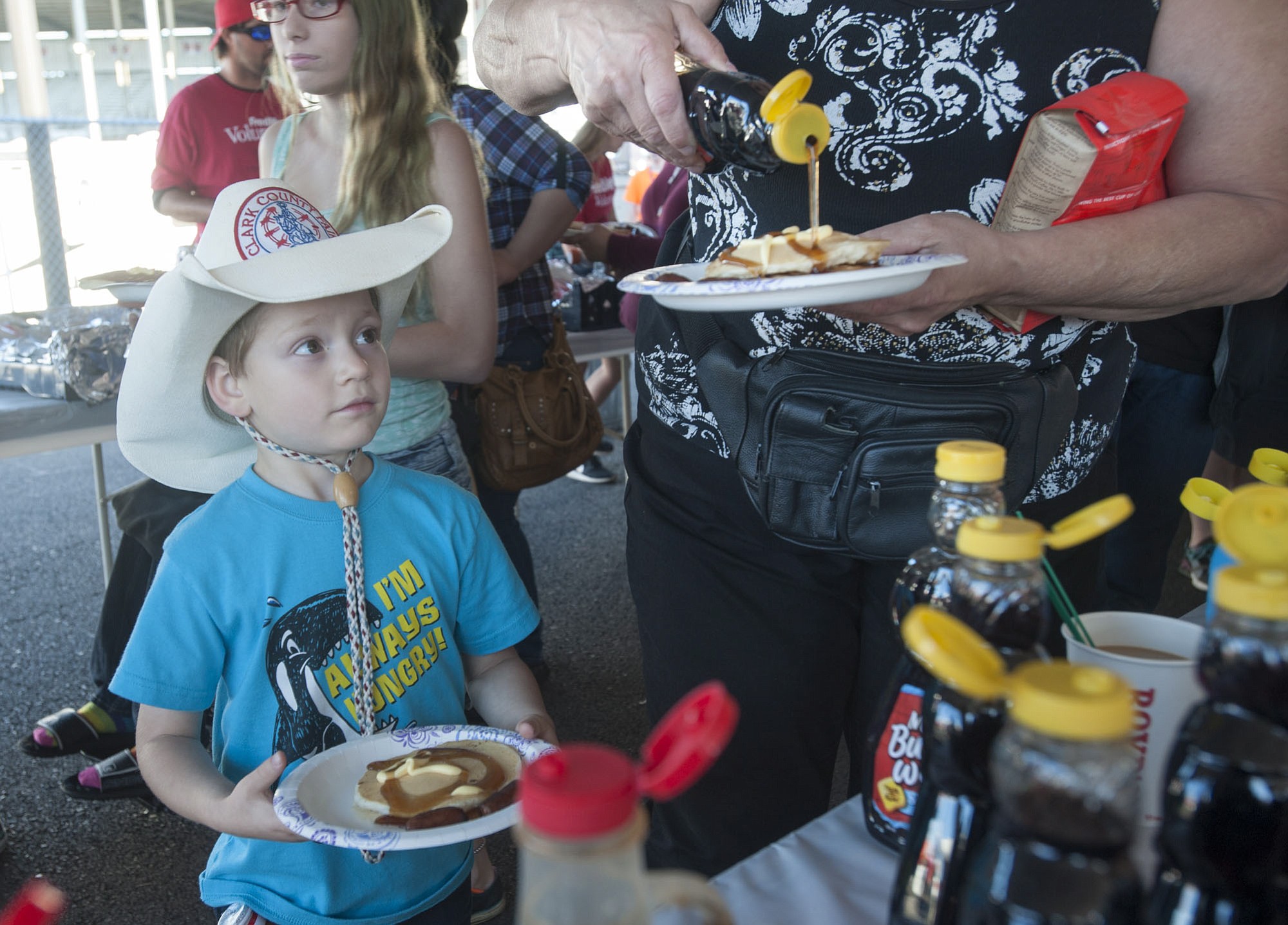 Dalton Anderson 4, watches as his grandma doles out syrup on their pancake breakfast at the Clark County Fairgrounds.