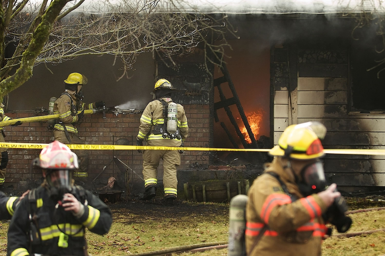 Firefighters work to contain a fatal house fire Friday, Jan.