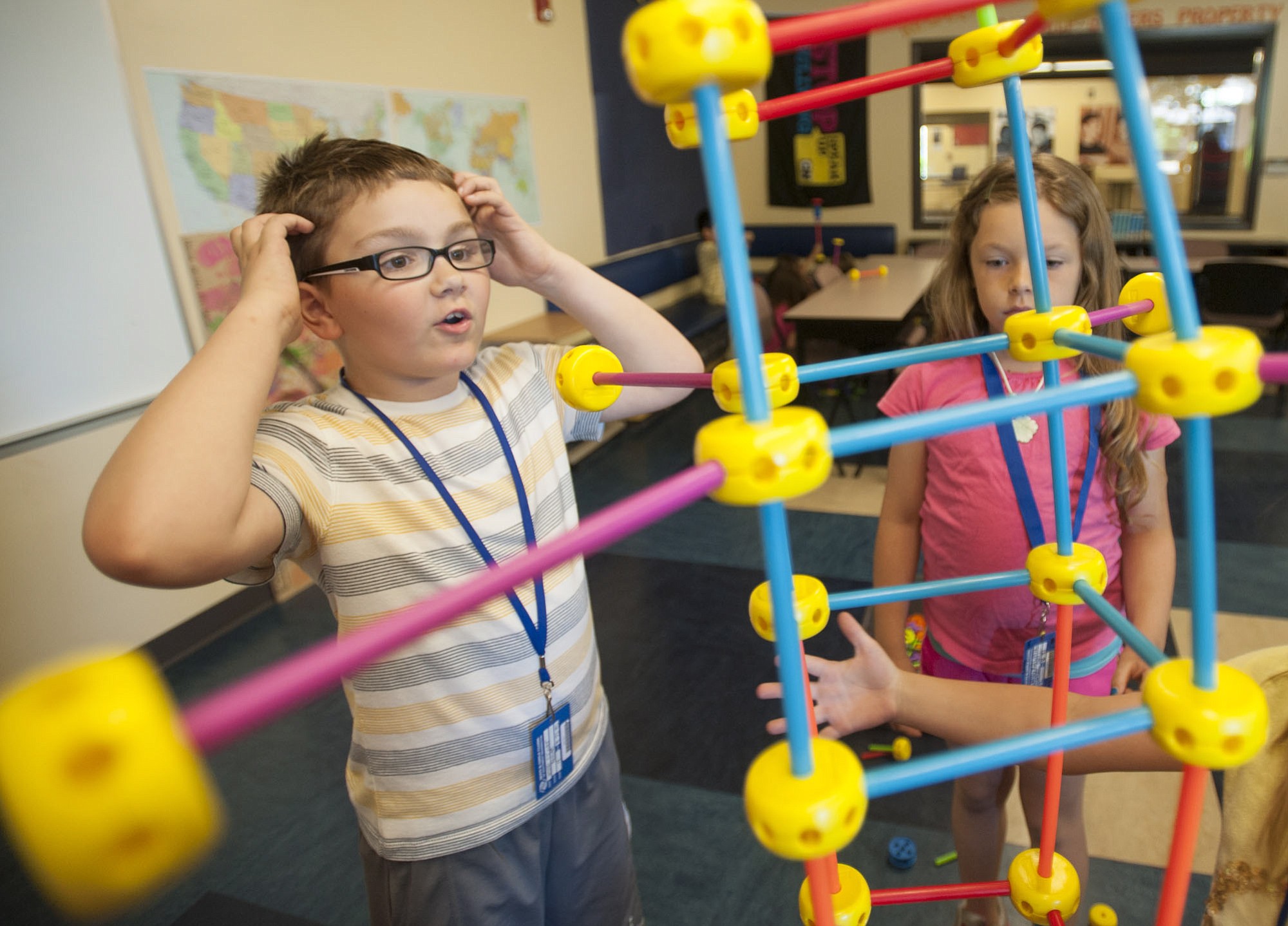 Jesse Oliver, left, and other kids build a Tinkertoys tower Tuesday afternoon at the Clinton and Gloria John Clubhouse.