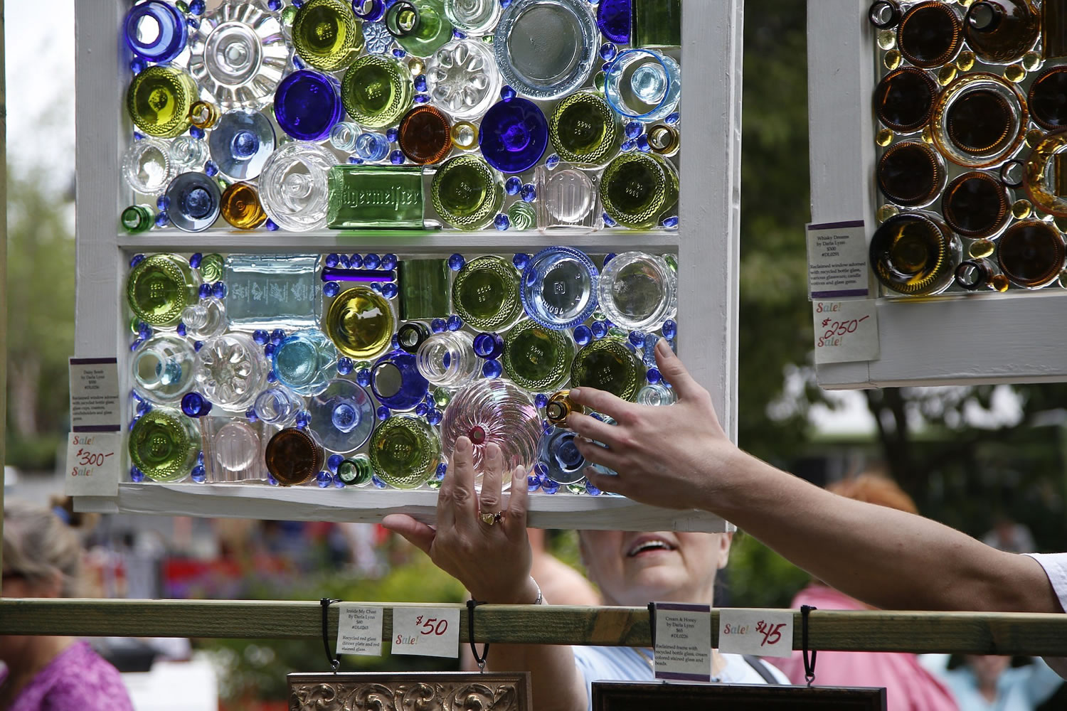 A &quot;window shopper&quot; feels one of Darla Lynn's recycled-glass creations Saturday at the Recycled Arts Festival at Esther Short Park.