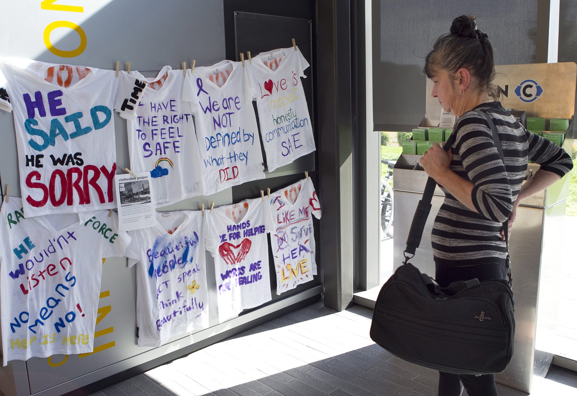Island Hunter looks Monday at the display of T-shirts created by domestic violence survivors at the Vancouver Community Library.