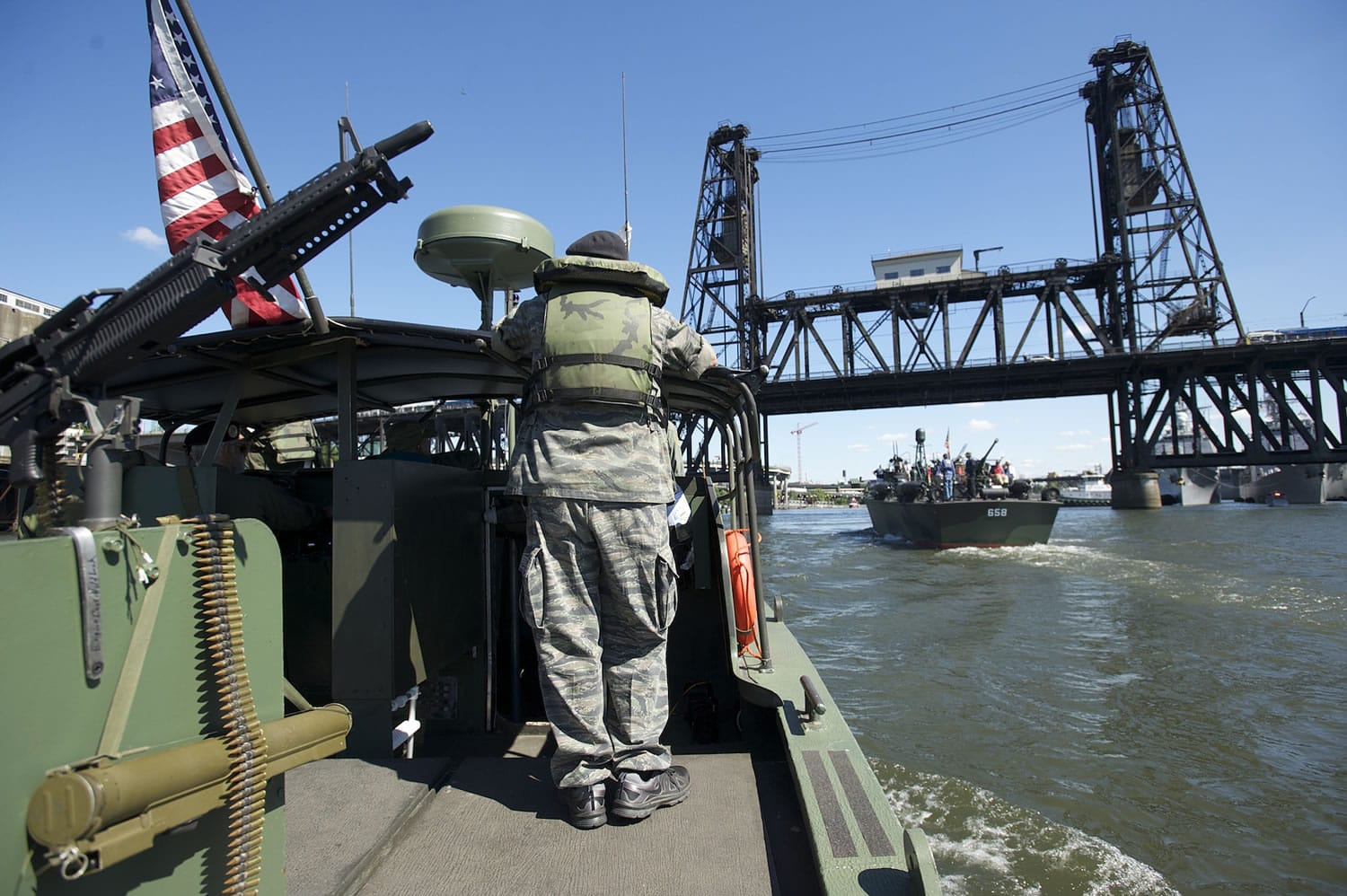 Photos by Steven Lane/The Columbian
A restored river patrol boat operated by the Gamewardens Association and PT-658, going under a bridge on the Willamette River, are the two historic participants in the 2015 Rose Festival fleet.