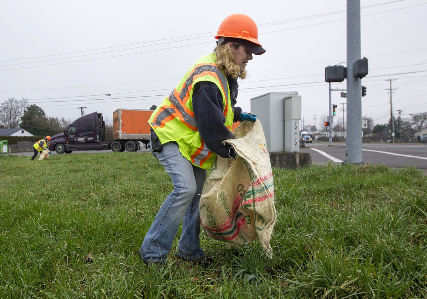 Benay Vincent collects litter found along Fourth Plain Road on Thursday in Vancouver.