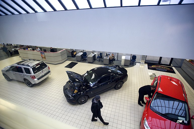Sales associates check the showroom floor Friday at Vancouver Ford.