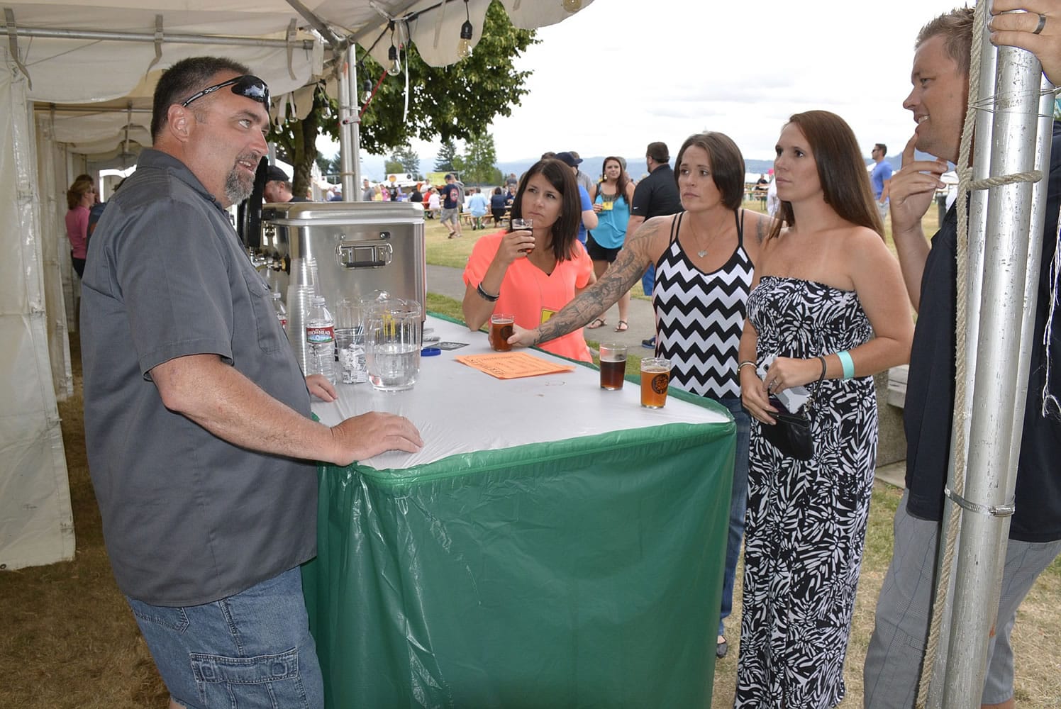 Washougal: Mark Zech, left, of Mill City Brew Werks in Camas serving guests at the first ever Weird Beer on the River fundraisers in Washougal on July 10 and 11.
