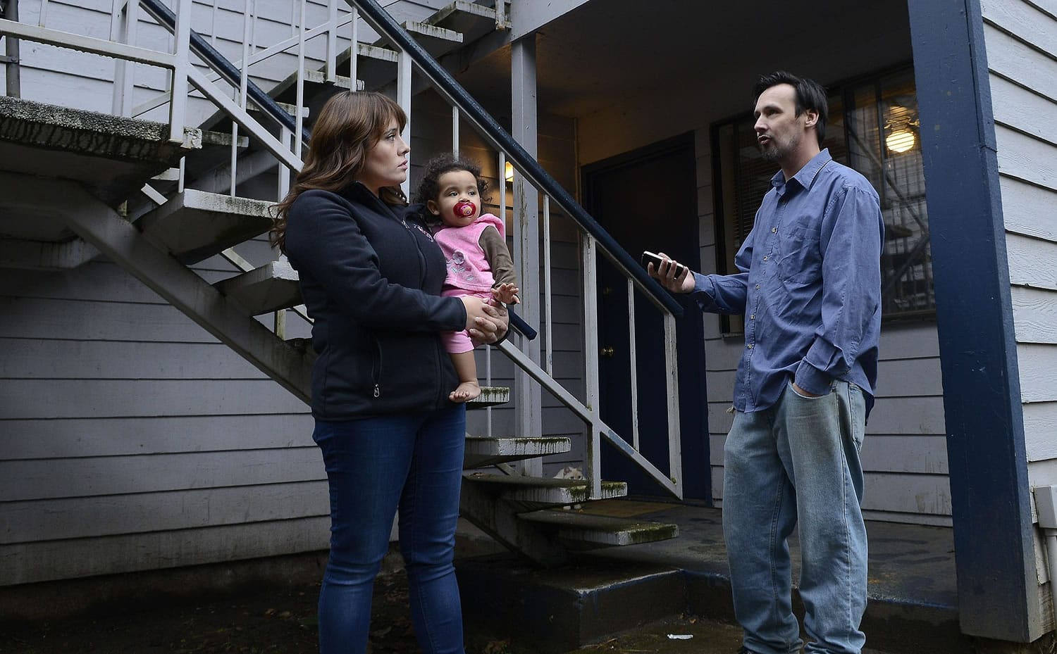 Natalia Mosley, holding onto daughter Isabel, chats with neighbor Kevin Giard about the upheaval at Courtyard Village Apartments, where new owners have begun notifying residents that they'll need to leave because of pending renovations and rises in rent.